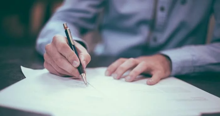 A person carefully comparing Will Writing Services Loughborough options on a clipboard or laptop